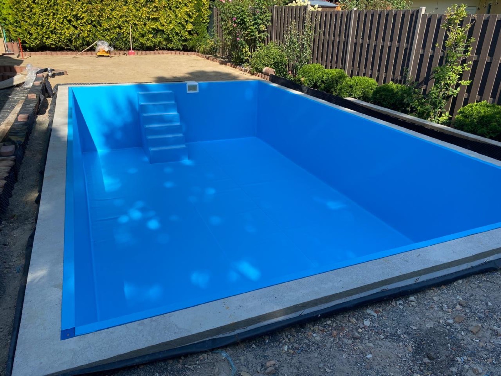 Neu eingebautes Poolbecken mit Einstiegstreppe während der Bauphase