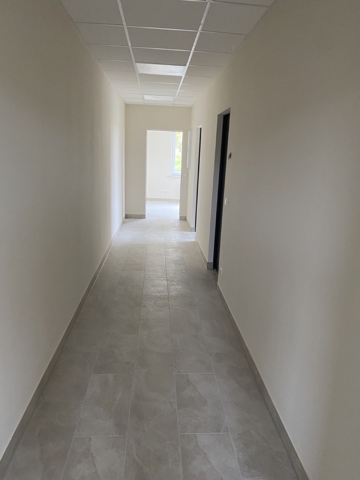 Fertig ausgebauter Innenflur mit hellen Wänden und großformatigem Fliesenboden, ausgebaut von LIEBESWERK in Wildau bei Berlin