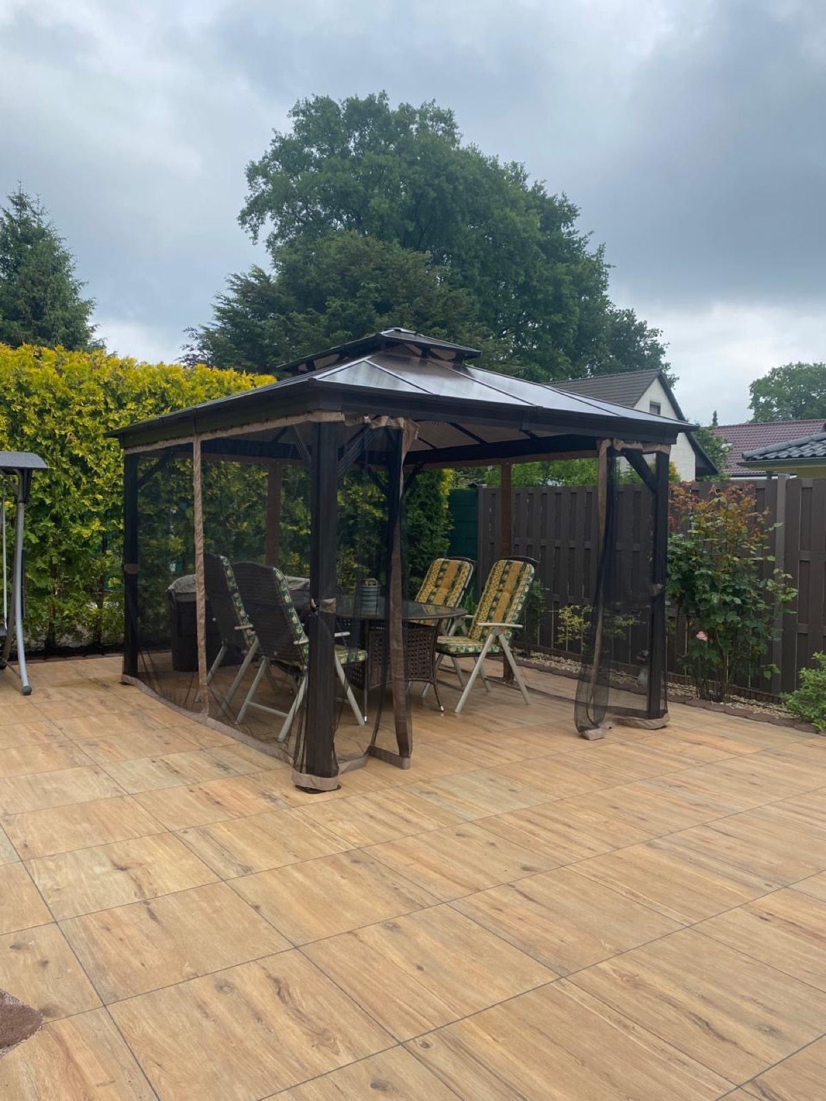 Freistehender Gartenpavillon mit festem Dach über einer Terrasse im Garten